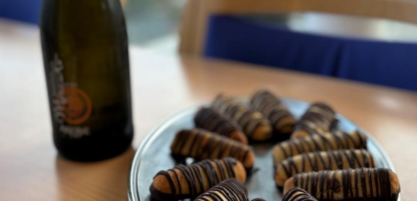 På et bord står et fad med kransekage og en flaske mousserende vin