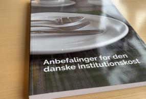 Bogen "Anbefalinger for den danske institutionskost" ligger på et skrivebord