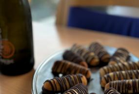 På et bord står et fad med kransekage og en flaske mousserende vin